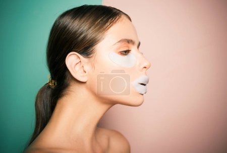 Photo for Taking care of her skin. Girl try eye patches. Daily pampering routine. Modern cosmetics. Eye patches concept. Reduce dark circles and puffiness. Skin moisture. Moisturizing patches for eyes and lips. - Royalty Free Image
