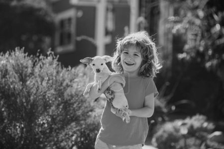 Foto de Paseo infantil con un perro cachorro al aire libre - Imagen libre de derechos