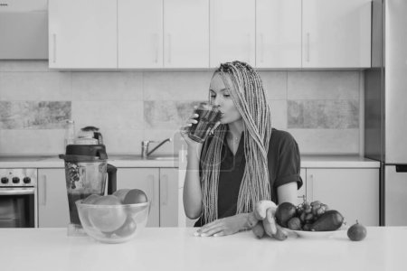 Photo for Woman with glass of natural detox smoothie in kitchen. Healthy eating concept. Fruits and vegetables spirulina. Natural antioxidant. Vegan concept - Royalty Free Image