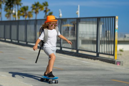 Photo for Child skateboarding at park in the city. Kid boy enjoy and having fun outdoor lifestyle. Child practicing extreme sport longboard skating on summer road - Royalty Free Image