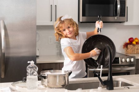 Photo for Child cleaning dishes with sponge. Cleaning supplies. Help clean-up. Housekeeping duties. Kid wash dishes. American kid learning domestic chores at home - Royalty Free Image