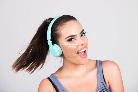 Photo for Happy young woman laughing cheerful istening music song in headphones Girl listens music, dancing and singing isolated over gray studio background - Royalty Free Image