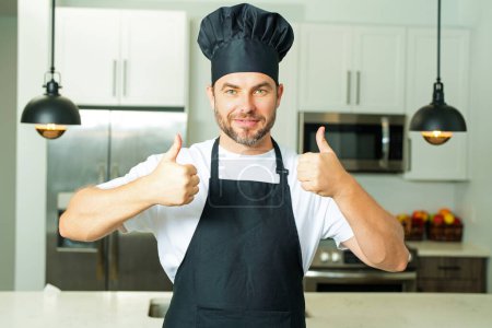 Téléchargez les photos : Joyeux chef cuisinier avec le pouce levé. Homme chef ou cuisinier boulanger homme dans la cuisine tablier. Portrait du chef cuisinier en béret. Concept de cuisine alimentaire - en image libre de droit