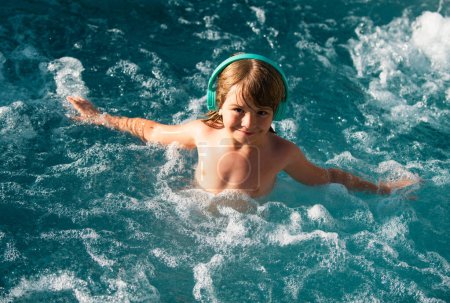 Téléchargez les photos : Garçon enfant heureux nager dans une piscine. Enfant d'été - en image libre de droit