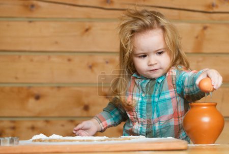 Téléchargez les photos : Petit garçon dans la cuisine cuisiner, jouer avec l'oeuf. Enfant pour casser les œufs - en image libre de droit
