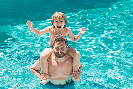 Téléchargez les photos : Père et fils nagent dans la piscine, week-end familial d'été. Papa et fils se détendent dans la piscine. Cours de natation. Vacances d'été - en image libre de droit