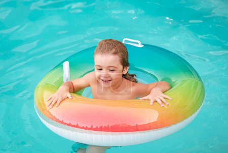 Téléchargez les photos : Vacances d'été. Week-end d'été pour enfants. Garçon dans la piscine. Garçon drôle sur le cercle en caoutchouc gonflable à aquapark - en image libre de droit