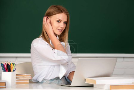 Foto de Estudiante enfocada, mujer joven en línea viendo webinar en el ordenador portátil, escuchando curso de educación de aprendizaje. Retrato de estudiante universitario alegre mirando a la cámara - Imagen libre de derechos