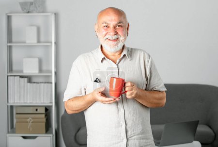 Téléchargez les photos : Heureux élégant européen mature homme d'âge moyen sur le lieu de travail. Homme d'affaires âgé et souriant, cheveux gris au bureau, portrait d'entreprise - en image libre de droit