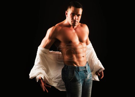 Foto de Quítate la camisa. Concepto de moda para hombre. Modelo de hombre sin camisa musculoso mostrando seis abdominales. Modelo sexy gay. sin camisa atlético caliente desnudo chico con abs - Imagen libre de derechos