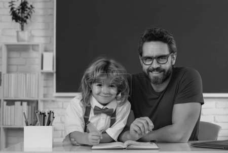Photo for First day at school. Cute little boy studying lesson in class. Teacher and little student portrait, teachers day - Royalty Free Image