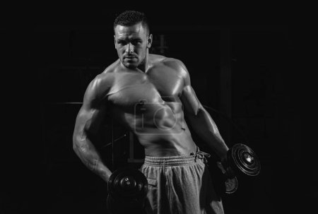 Foto de Ejercicio de hombre atlético fuerte con pesas en el gimnasio. Estilo de vida deportivo - Imagen libre de derechos