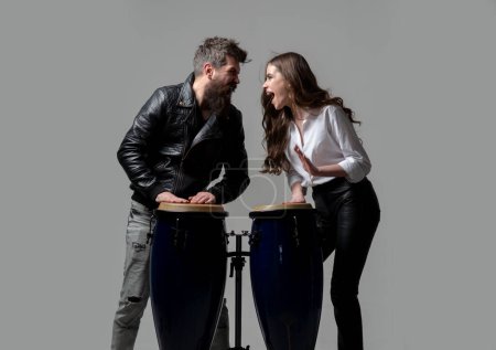 Téléchargez les photos : Couple frappant sur des tambours conga isolés sur fond gris. Tambours Conga - en image libre de droit