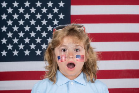 Foto de Día de la independencia de la celebración infantil 4 de julio. Concepto de Estados Unidos de América. Signo de bandera americana en la mejilla infantil. patriota americano, ventilador - Imagen libre de derechos