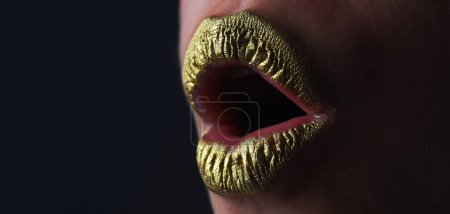 Téléchargez les photos : Lèvres à paillettes dorées. La bouche de la femme se ferme. Rouge à lèvres doré. Bouche d'or de luxe glamour. Peinture dorée sur les lèvres. Des lèvres d'or sur la bouche des femmes. Corps métallique. Concept or - en image libre de droit