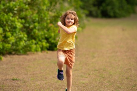 Foto de Mañana corriendo corriendo con niños. Corredor de niños corriendo en la naturaleza. Estilo de vida activo para niños sanos. Un chico deportivo corriendo por la calle. Deportivo niño corredor corriendo en parque - Imagen libre de derechos