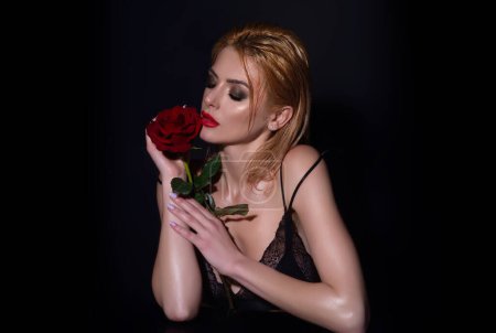 Foto de Citas románticas o propuesta. Chica de belleza con rosa roja. Hermosa mujer sensual sostienen flores, retrato de estudio - Imagen libre de derechos