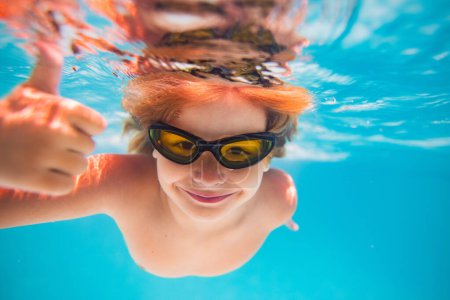 Photo for Child in swimming pool underwater with thumbs up. Underwater kid swim in pool. Child boy swimming and diving underwater in pool. Summer family summer vacation with children. Underwater pool kids - Royalty Free Image