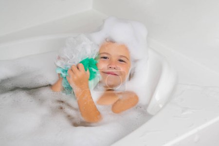 Photo for Kids face in foam. Child in the bath with bubbles. Happy child enjoying bath time. Little boy smiling in the bath with soap foam. Child bathes in a bath with foam - Royalty Free Image