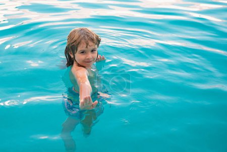 Téléchargez les photos : Joyeux gamin jouant dans la piscine. Jeux d'eau pour enfants. Vacances en famille et activité estivale - en image libre de droit