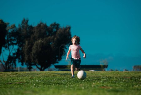Foto de Niños de fútbol, niños juegan al fútbol al aire libre. Chico joven con pelota de fútbol haciendo patada. Jugadores de fútbol en movimiento. Lindo chico en acción deportiva. Niños entrenando fútbol - Imagen libre de derechos