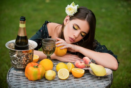 Foto de Retrato de mujer sexy relajándose y comiendo fruta al aire libre. Dieta exótica de verano, frutas tropicales. Belleza mujer cara - Imagen libre de derechos