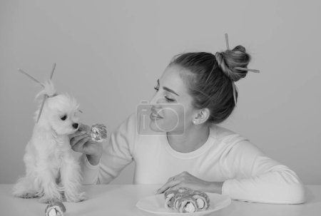 Téléchargez les photos : Beauté femme sexy avec chien manger des sushis. Des sushis. mannequin fille manger sushi avec baguettes. Parfait maquillage et coiffure bob avec baguettes, nourriture japonaise - en image libre de droit
