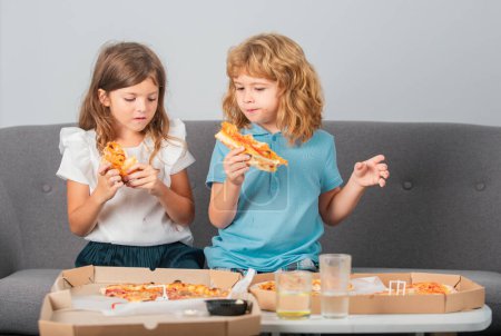 Photo for Happy daughter and son eating pizza. Children kids, little girl and boy eat pizza - Royalty Free Image