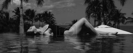 Téléchargez les photos : Femme élégante et sexy dans la piscine à débordement et bénéficie de la vue sur la mer bleue. Bannière pour en-tête de conception, espace de copie - en image libre de droit