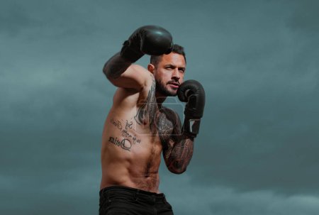Photo for Portrait of tough male boxer posing in boxing gloves. Professional fighter ready for boxing match. Sportsman muay thai boxer fighting. Strong muscular boxing man - Royalty Free Image