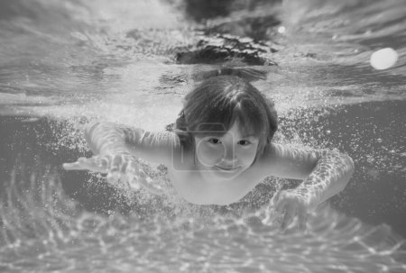 Téléchargez les photos : Enfant nager et plonger sous l'eau dans la piscine - en image libre de droit