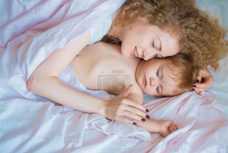 Photo for Mother and baby sleeping in the bed. Family morning in bedroom - Royalty Free Image