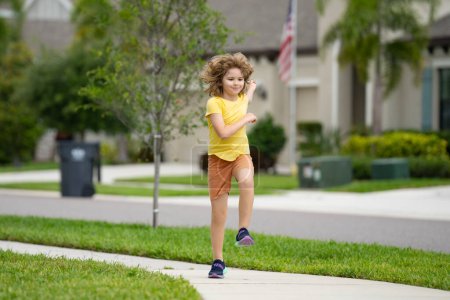 Téléchargez les photos : Jeune enfant sportif courir le jogging et l'entraînement en plein air. Course et sport sain pour les enfants. Enfant qui court sur les enfants de la rue fitness. Entraînement en plein air, jogging matinal. Exercice de course - en image libre de droit