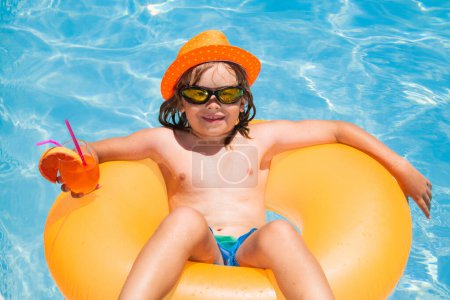 Photo for Kid floating in pool. Child relaxing in pool, drink summer cocktail. Outdoor summer activity for children. Happy child having fun at swimming pool on summer day. Kids summer cocktail in pool - Royalty Free Image