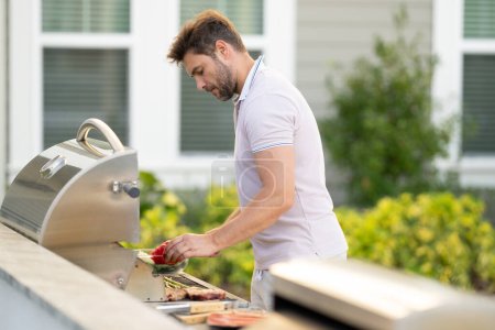 Photo for Grill cook. Chef with BBQ cooking tools. Barbecue and grill. Picnic and barbecue party. Chief cook with utensils for barbecue grill. Barbeque on holiday picnic. Man grilling a steak on BBQ - Royalty Free Image