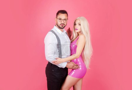Photo for Romantic Fashion glamour woman in pink dress and elegant man in suit and shirt. Pink studio background - Royalty Free Image