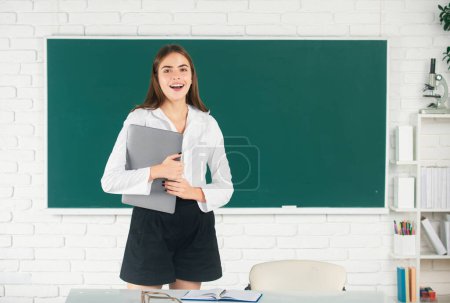 Photo for Female college student holding laptop in classroom, preparing for exam. Girl student with pc technology, distance learning - Royalty Free Image