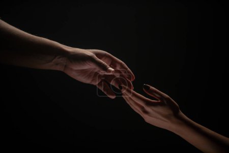 Photo for Two hands. Helping hand to a friend. Rescue or helping gesture of hands. Concept of salvation. Hands of two people at the time of rescue, help. Isolated on black background - Royalty Free Image