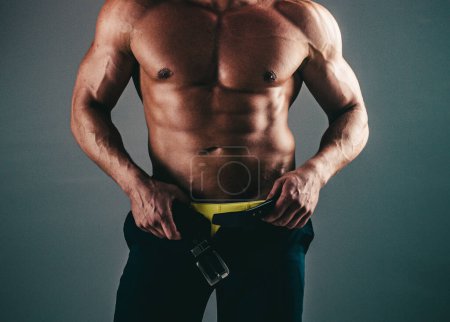 Foto de Muscular Gay sexy con seis pack abs en estudio con iluminación dramática sobre un fondo oscuro. Hombres abdominales. Músculo abdominal fitness. Pack de seis hombres - Imagen libre de derechos