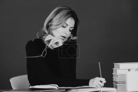 Foto de Pretty young high school or college teacher on the chalkboard. Young caucasian female business woman portrait with blackboard background - Imagen libre de derechos