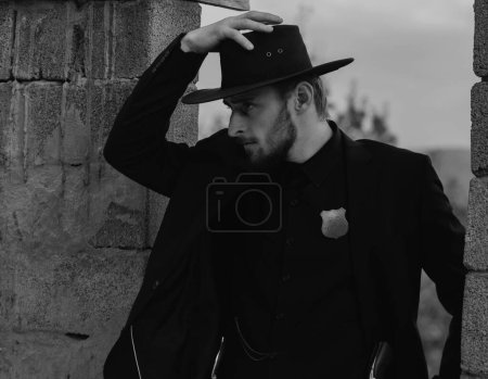 Photo for Sheriff or cowboy in black suit and cowboy hat. Man with west vintage pistol revolver gun. American western, sheriff - Royalty Free Image