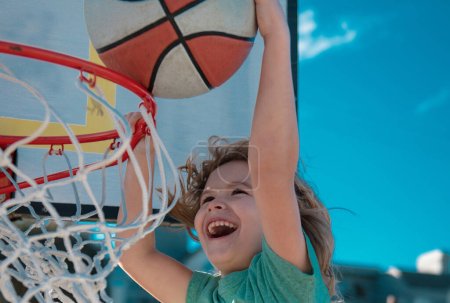 Foto de Chico divertido emocionado jugando baloncesto. Retrato infantil de primer plano. Divertido niño cara deportiva - Imagen libre de derechos