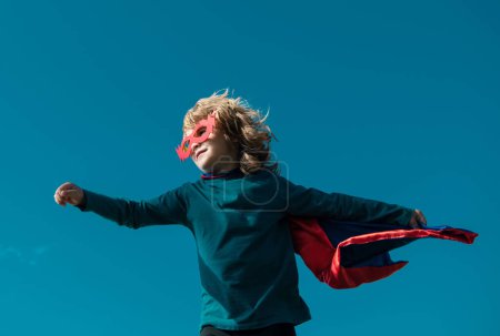 Téléchargez les photos : Super héros enfant dans un manteau de super-héros rouge. Concept de super héros - en image libre de droit