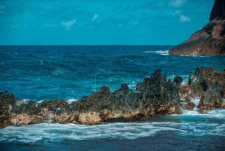 Foto de Salpicando olas en la roca en el mar. Ola golpeó la piedra en el océano con un fondo de agua - Imagen libre de derechos