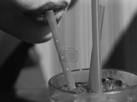 Close up straw in mouth. Summer juice cocktail drink. Straw in lips taste fresh cocktail. Sexy woman lips
