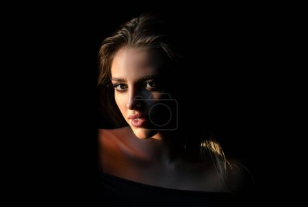 Photo for Beautiful young woman portrait on black. Sensual face of elegant female model in studio. Elegant lady. Dramatic light on sensual seduction woman face - Royalty Free Image