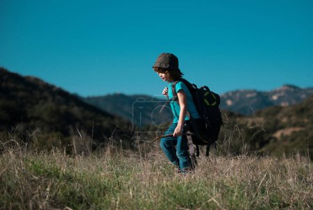 Foto de Niño pequeño con mochila de senderismo en las montañas escénicas. Chico turista local va en una caminata local - Imagen libre de derechos