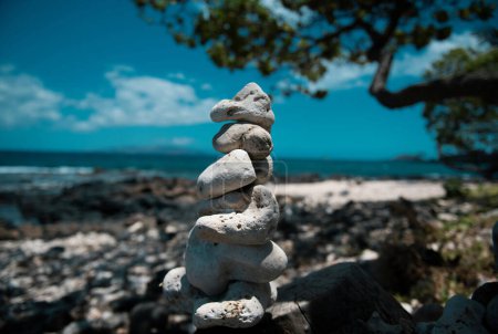 Téléchargez les photos : Tour de pierres sur fond de plage de mer. Détente sur la plage tropicale, avec une pile de pierres - en image libre de droit