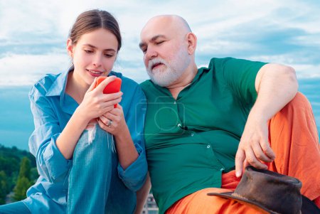 Photo for Granddaughter with elderly grandfather. Senior man Granddad with mobile phone smiling make self portrait webcam view. Older younger generations - Royalty Free Image
