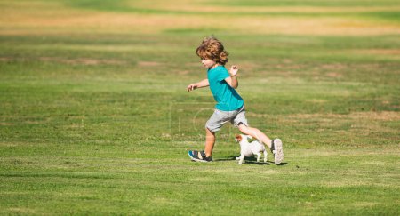 Foto de Perro que corre. Niño feliz correr con un perro al aire libre - Imagen libre de derechos